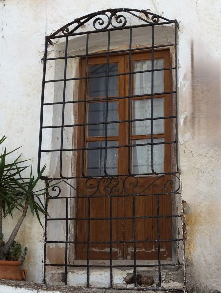 Archivo:Bédar, Almería, Región Histórica de Granada. Antigua reja tradicional que cierra una puerta-ventana típica de Almería. Obsérvese como no tiene soldaduras sino remaches para unir las diferentes piezas..jpg