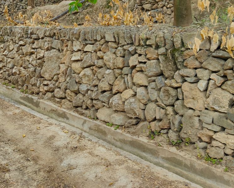 Archivo:Pinos del Valle, Región de Granada, España. Excelente trabajo de piedra seca, un muro fabricado con piedras sueltas e irregulares que se corona con una fila de lajas verticales..jpg